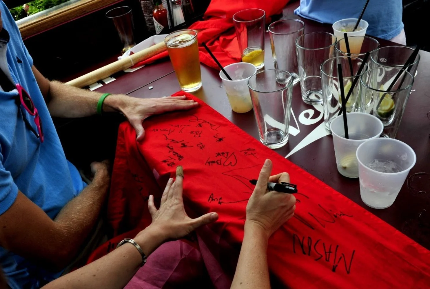 At Nellie’s Sports Bar, Anna McCrerey of Baltimore, was one of many who signed an equality flag brought to the bar to celebrate the historic Supreme Court ruling on Friday. (Michael S. Williamson/The Washington Post)